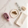 Brosse Cascadhe en flat lay sur marbre avec accessoires beaute minimalistes